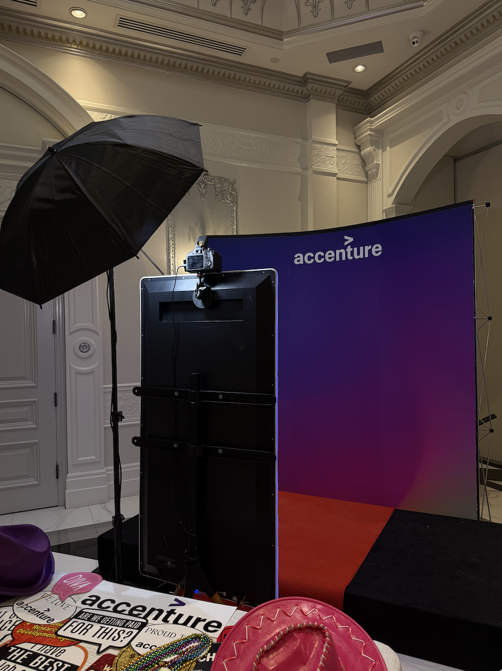 Mona's Booth mirror photo booth with a branded Accenture backdrop and red carpet at a corporate event