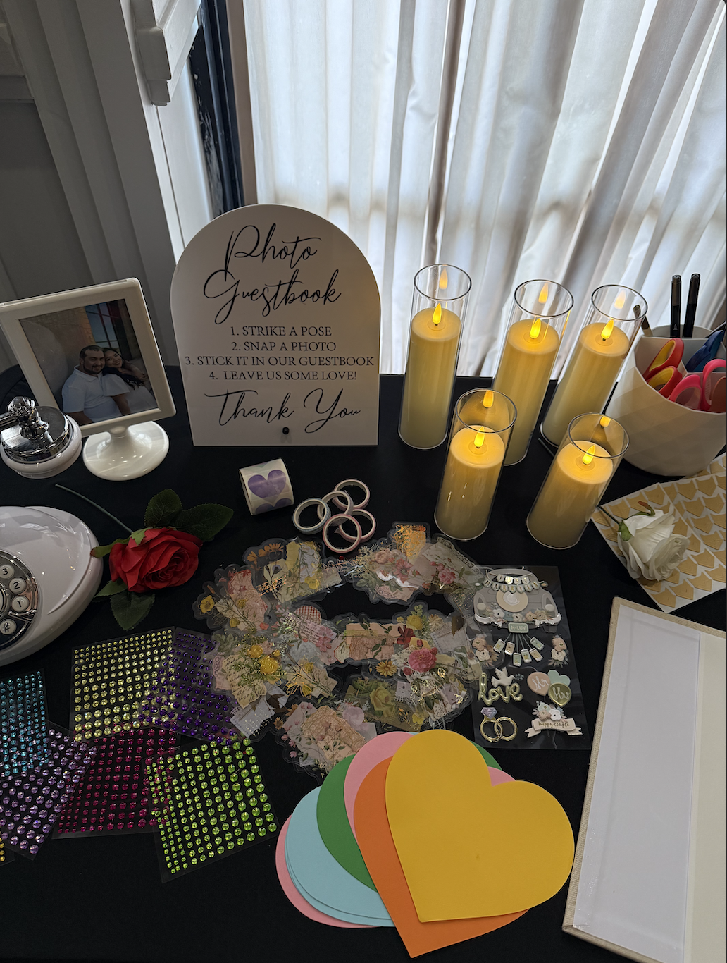 Photo guestbook table with arched sign, candles, stickers and colourful paper hearts